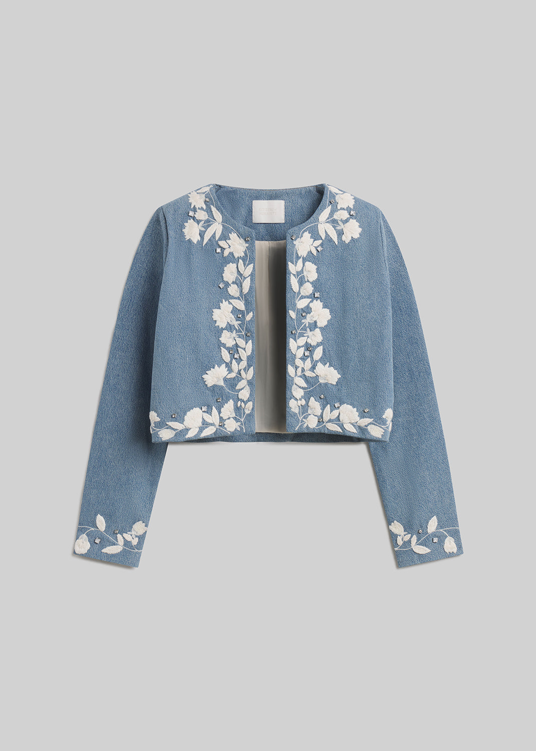 Light blue cropped denim jacket with white floral embroidery on grey background
