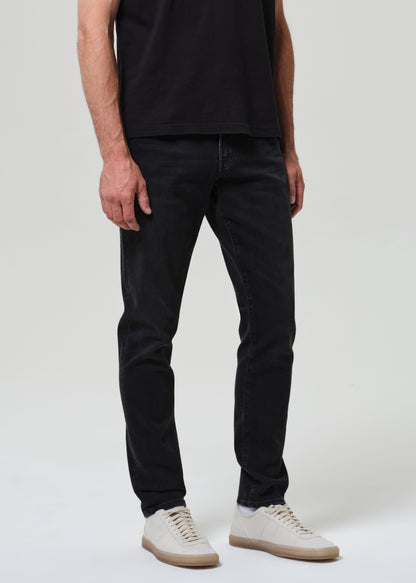 Person wearing black tee with dark washed black jeans