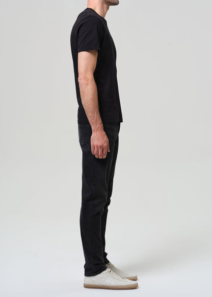 Person wearing black tee with dark washed black jeans