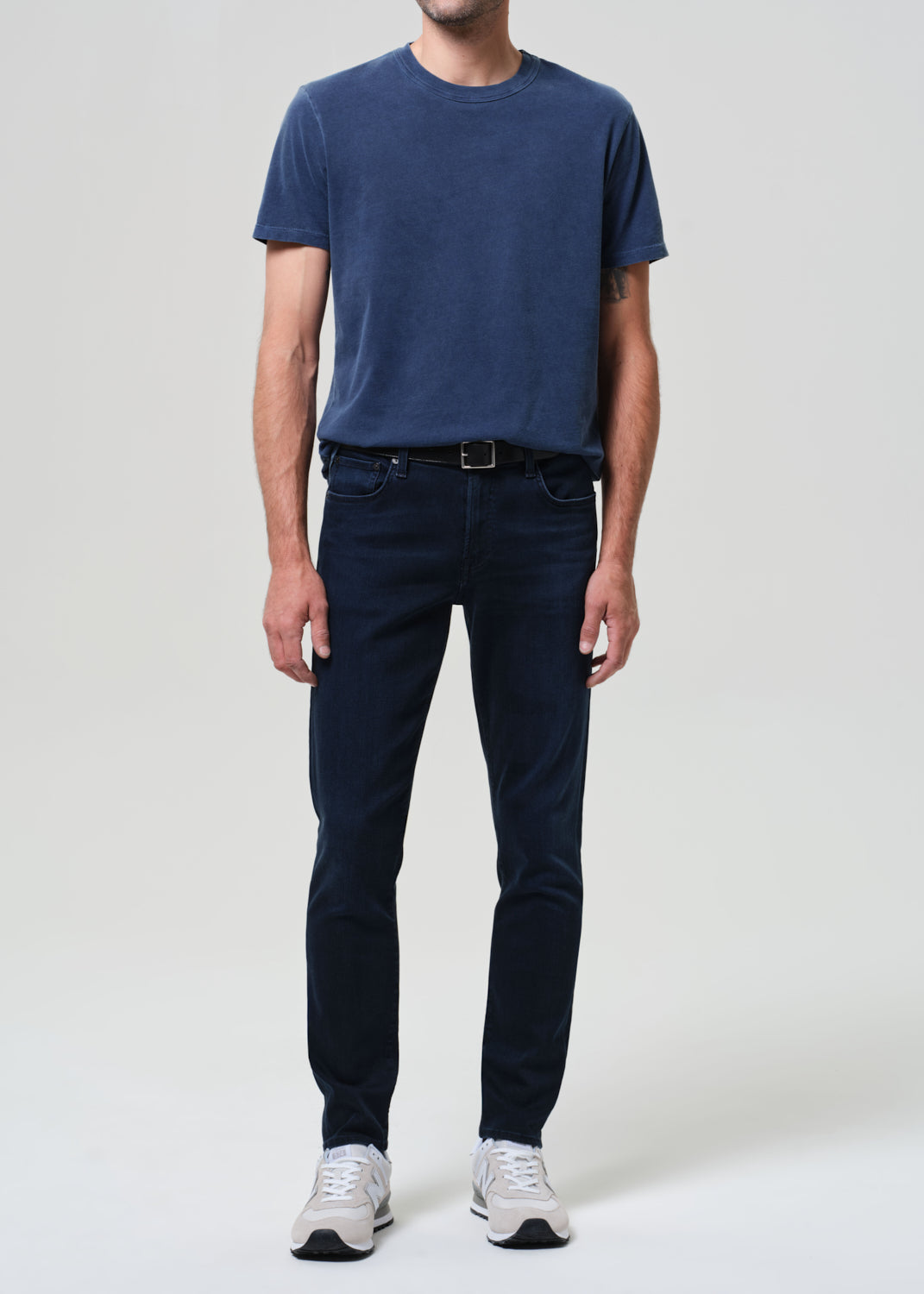 Person wearing a blue tee with dark blue jeans