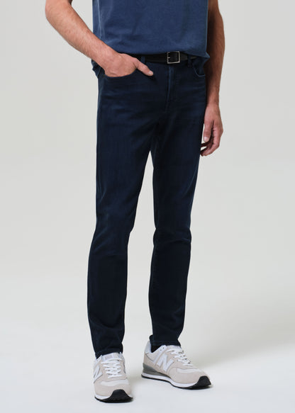 Person wearing a blue tee with dark blue jeans