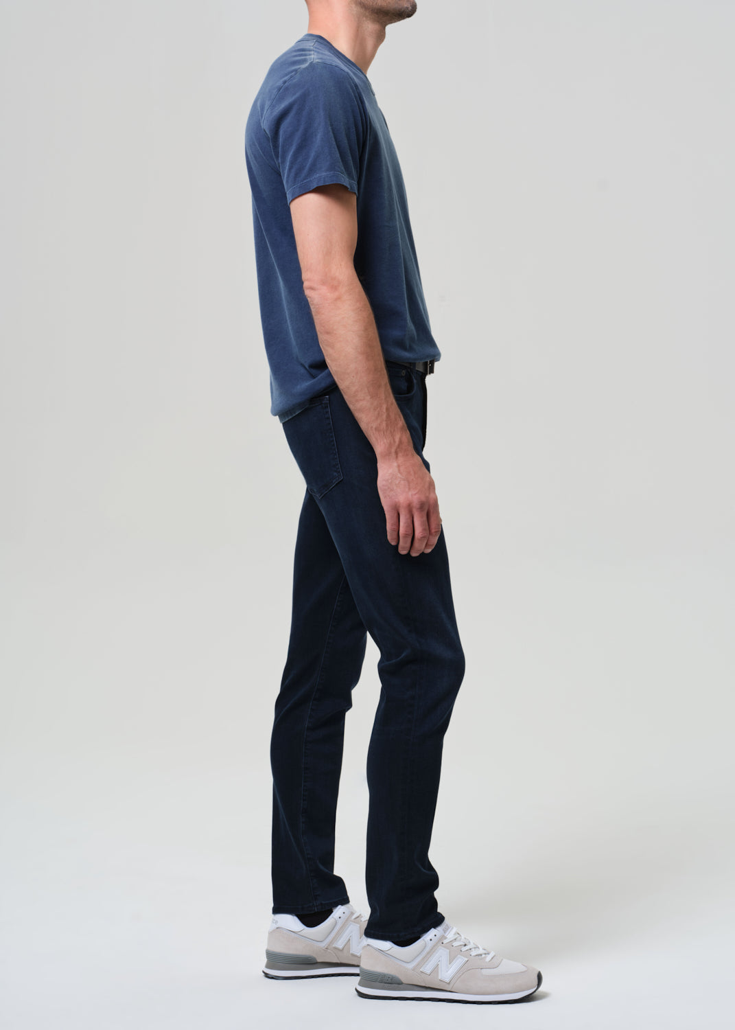 Person wearing a blue tee with dark blue jeans