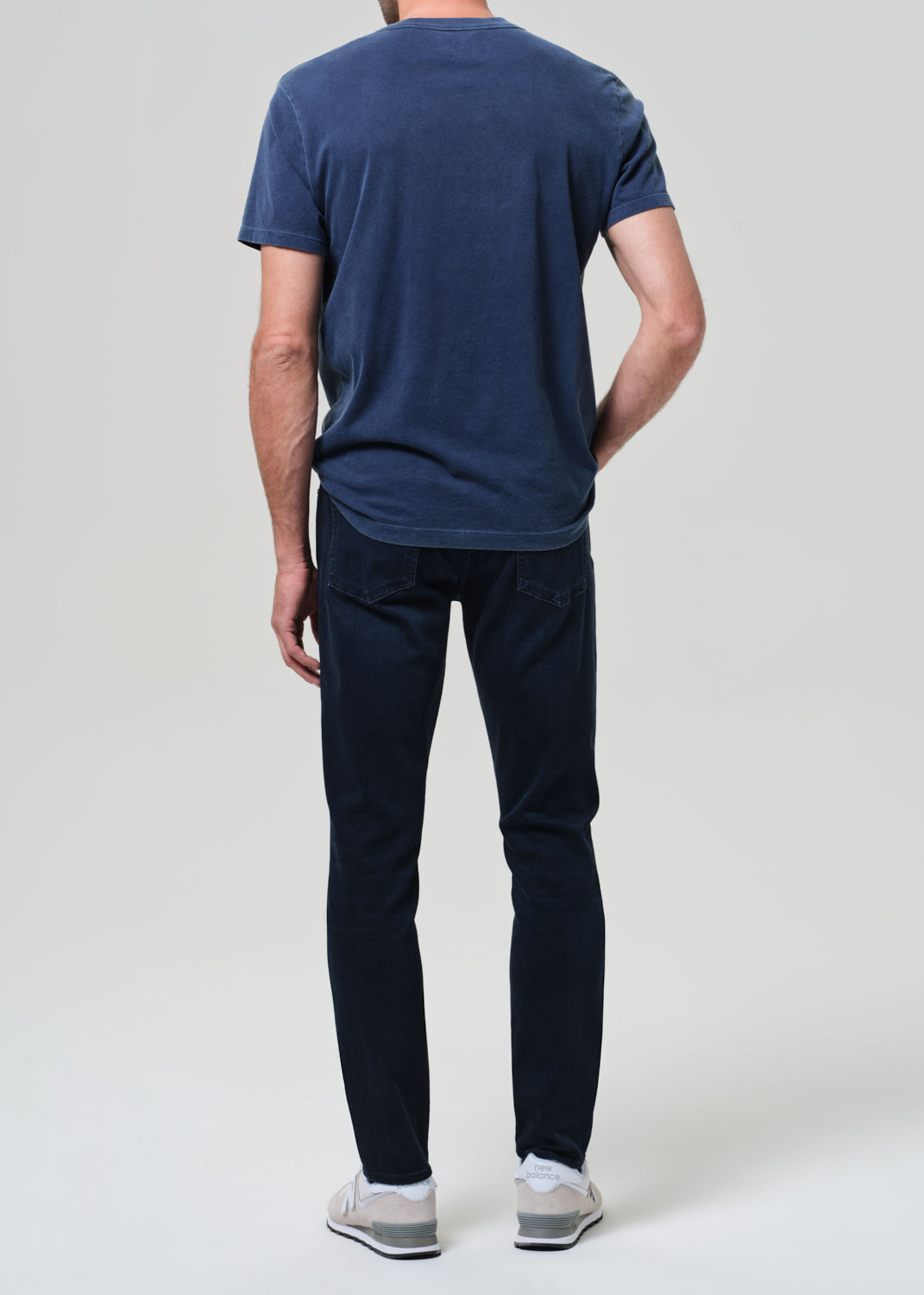 Person wearing a blue tee with dark blue jeans