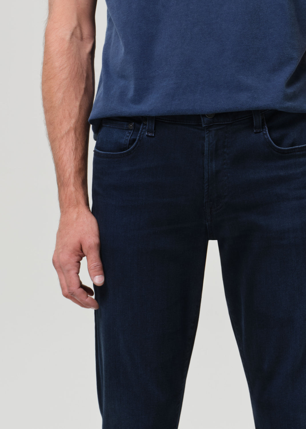 Person wearing a blue tee with dark blue jeans