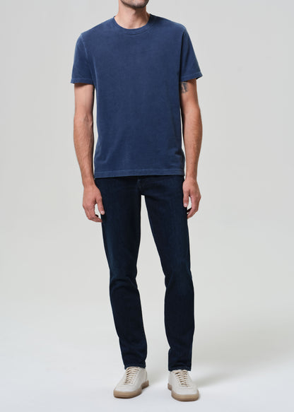 Person wearing a blue t-shirt and dark jeans