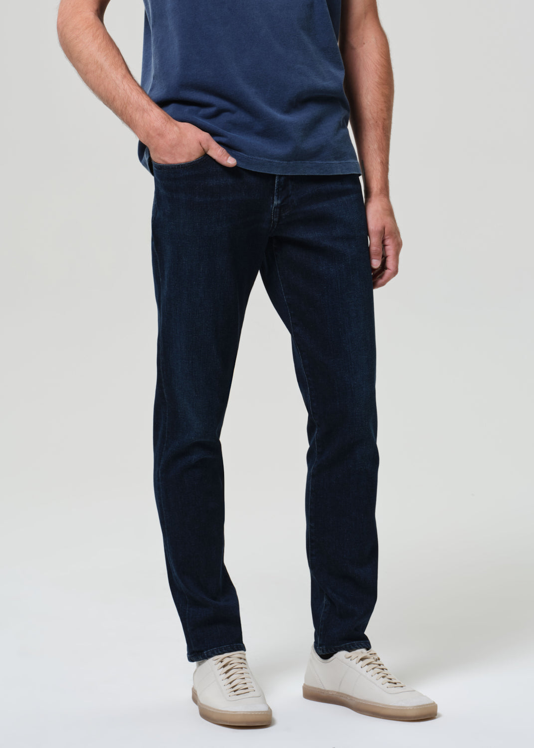 Person wearing a blue t-shirt and dark jeans
