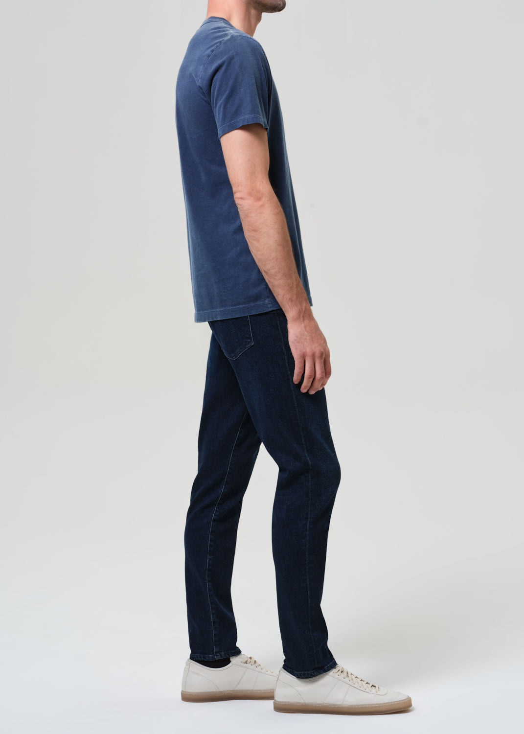 Person wearing a blue t-shirt and dark jeans
