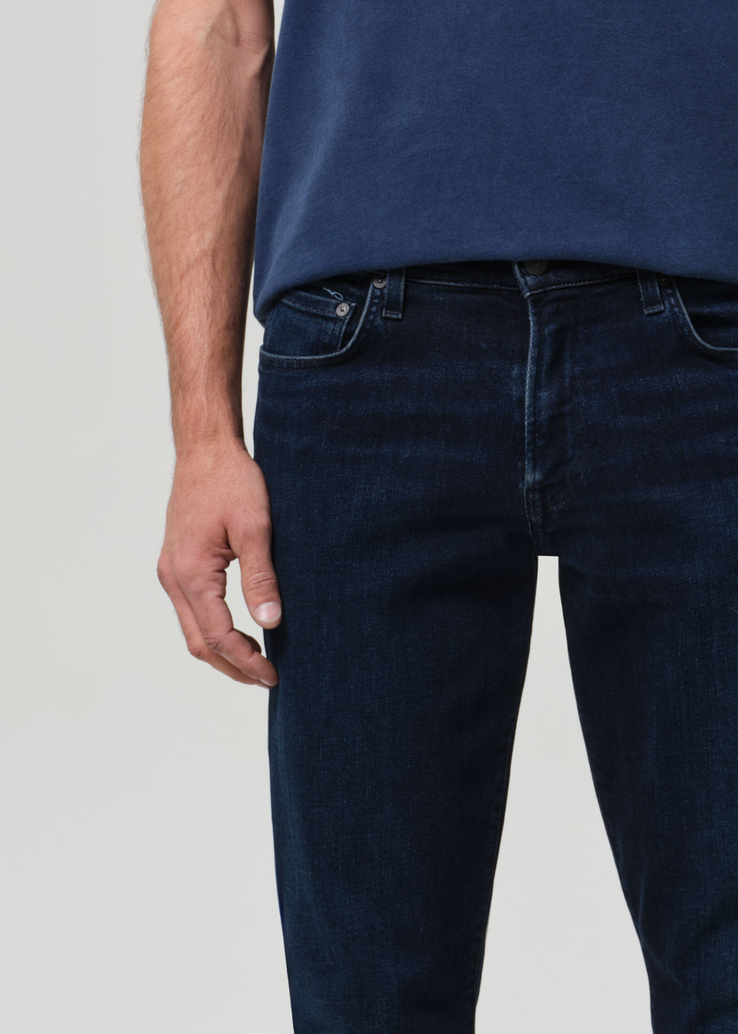 Person wearing a blue t-shirt and dark jeans