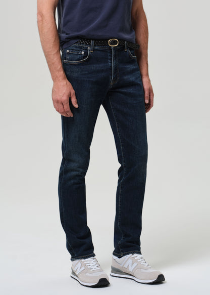 Person wearing a navy t-shirt and dark jeans on a plain background