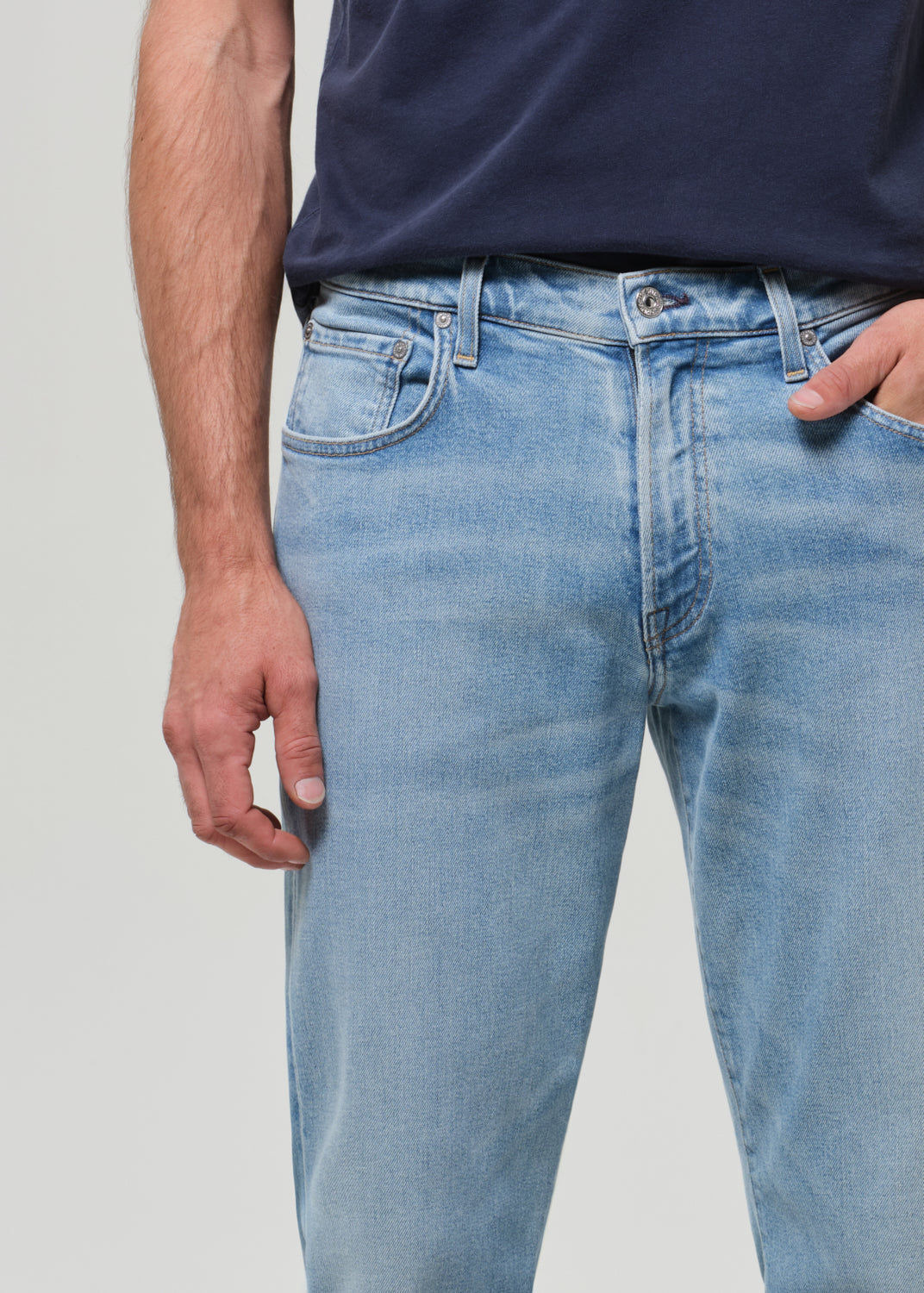 Light blue jeans worn by a person on a plain background