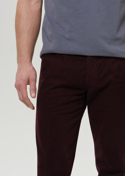 Person wearing a navy sweatshirt and burgundy pants on a light gray background