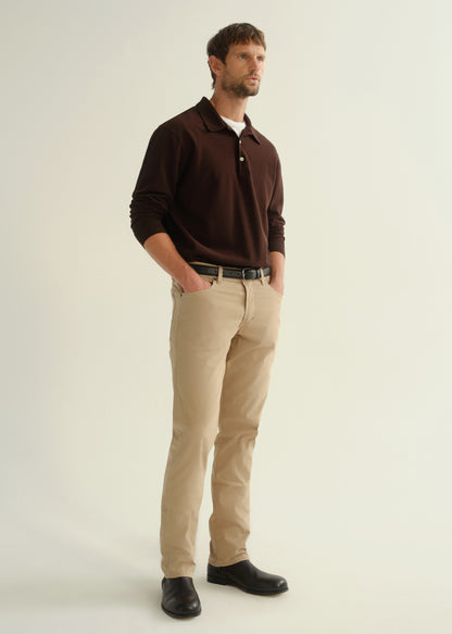 Person wearing a dark brown collared pullover sweatshirt, beige pants, and black leather boots, angled front full body view on a light grey background.