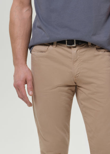 Man wearing a gray t-shirt and beige pants on a grey background