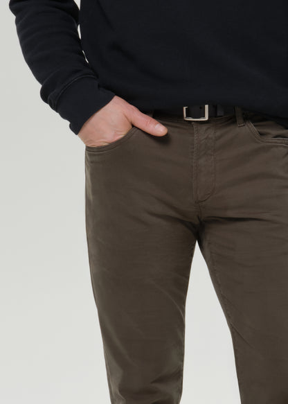 Man wearing a black sweatshirt and olive pants on a grey background