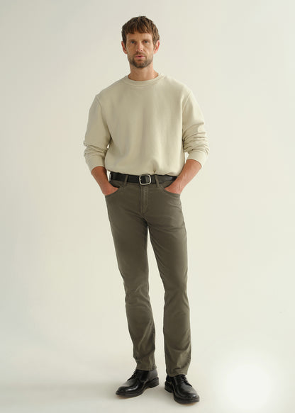 Person wearing a light grey crewneck sweatshirt, dark olive green pants, and black leather shoes, front full body view on a light grey background.