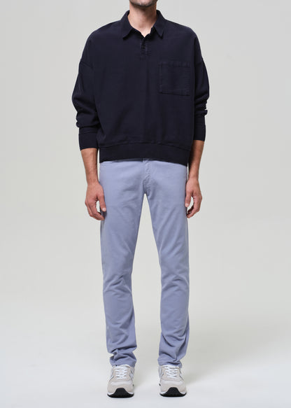 Person wearing a navy polo and light blue pants on a plain background