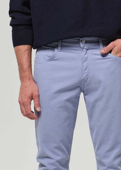 Person wearing light blue jeans and a dark sweater on a plain background