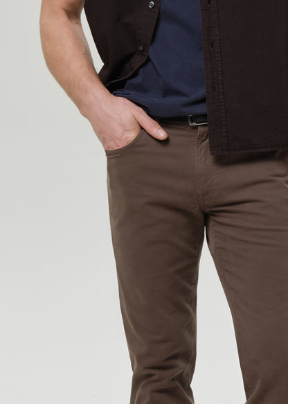 Person wearing brown pants with a grey background