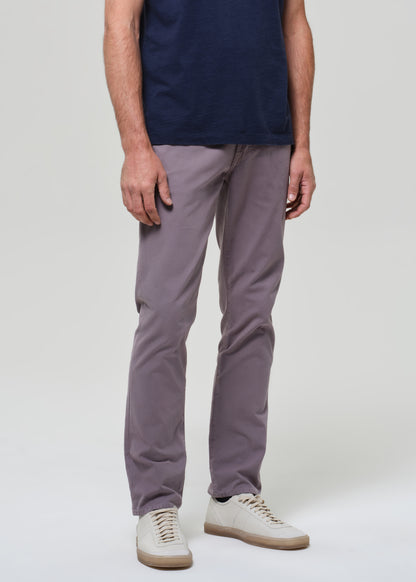 Person wearing a navy t-shirt and grey pants on a grey background