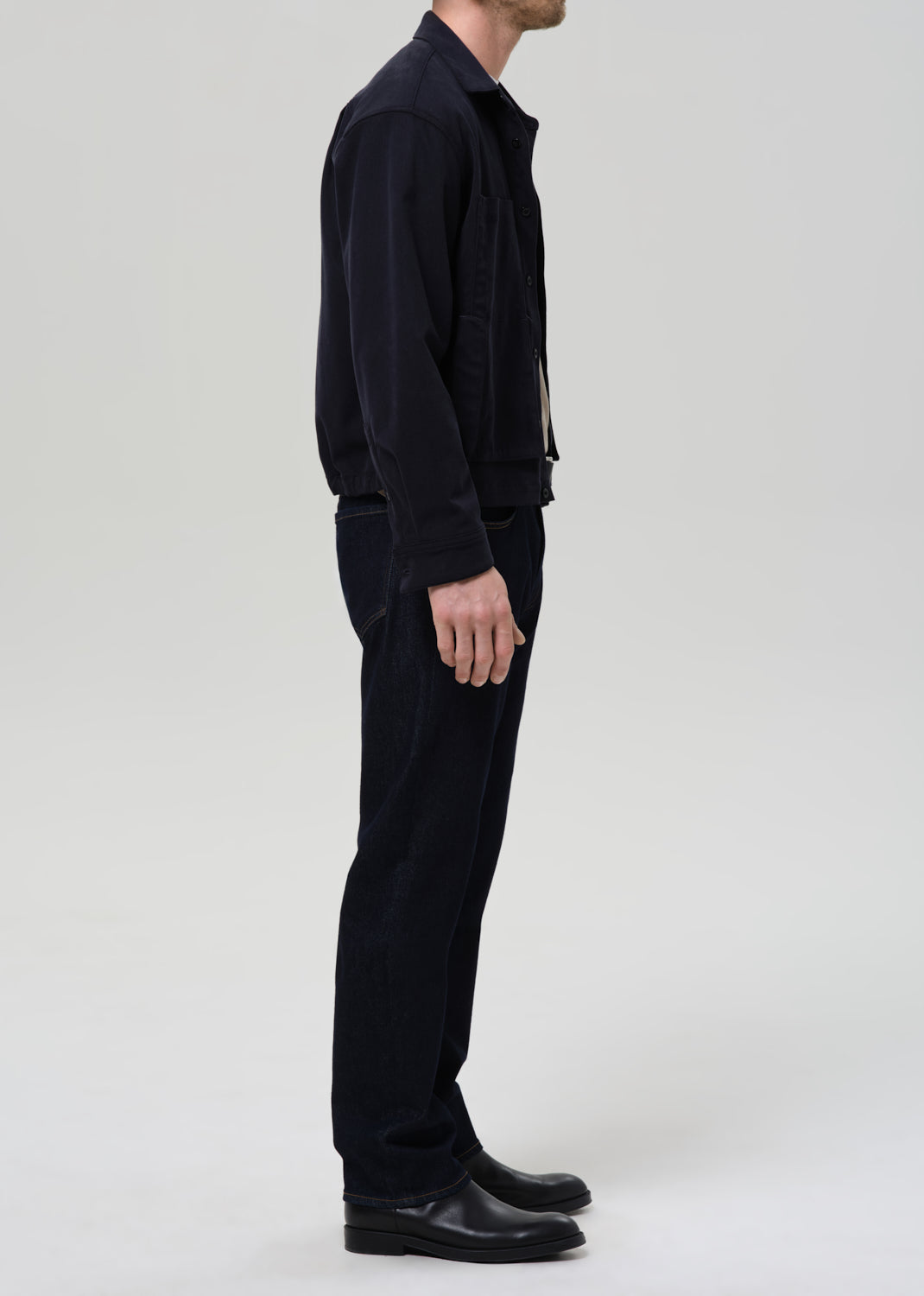 Person wearing a black outfit on a grey background