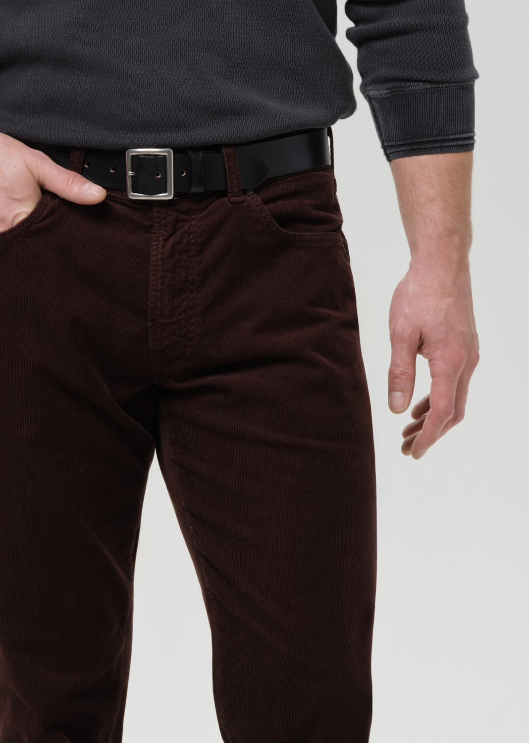 Brown pants worn by a person on a grey background