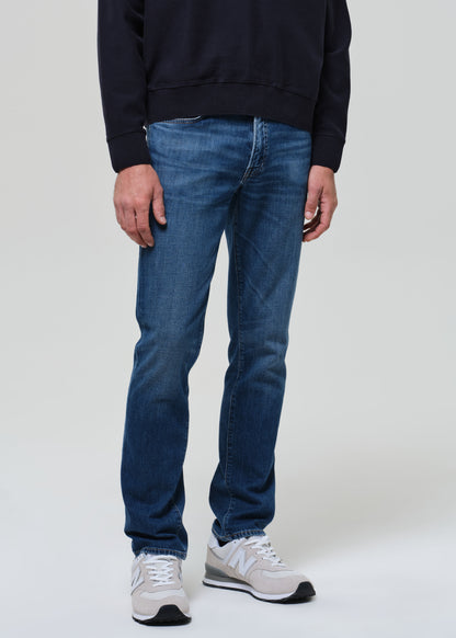 Person wearing blue jeans and a dark sweater on a white background