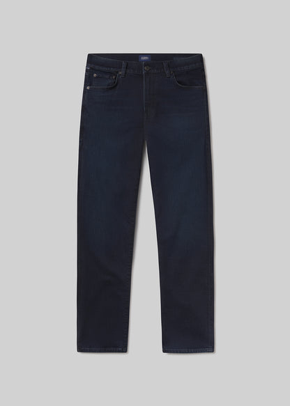 Flat lay of dark blue jeans on a light grey background