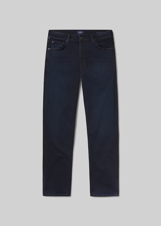 Flat lay of dark blue jeans on a light grey background