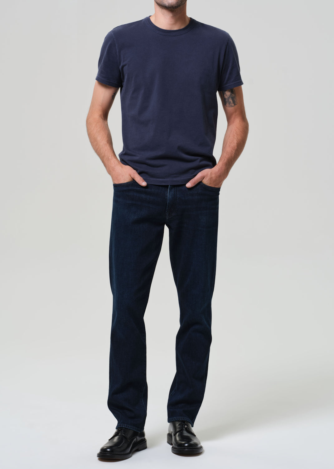 Person wearing a navy t-shirt and dark jeans 