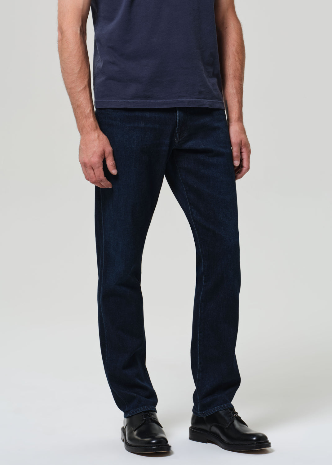Person wearing a navy t-shirt and dark jeans 