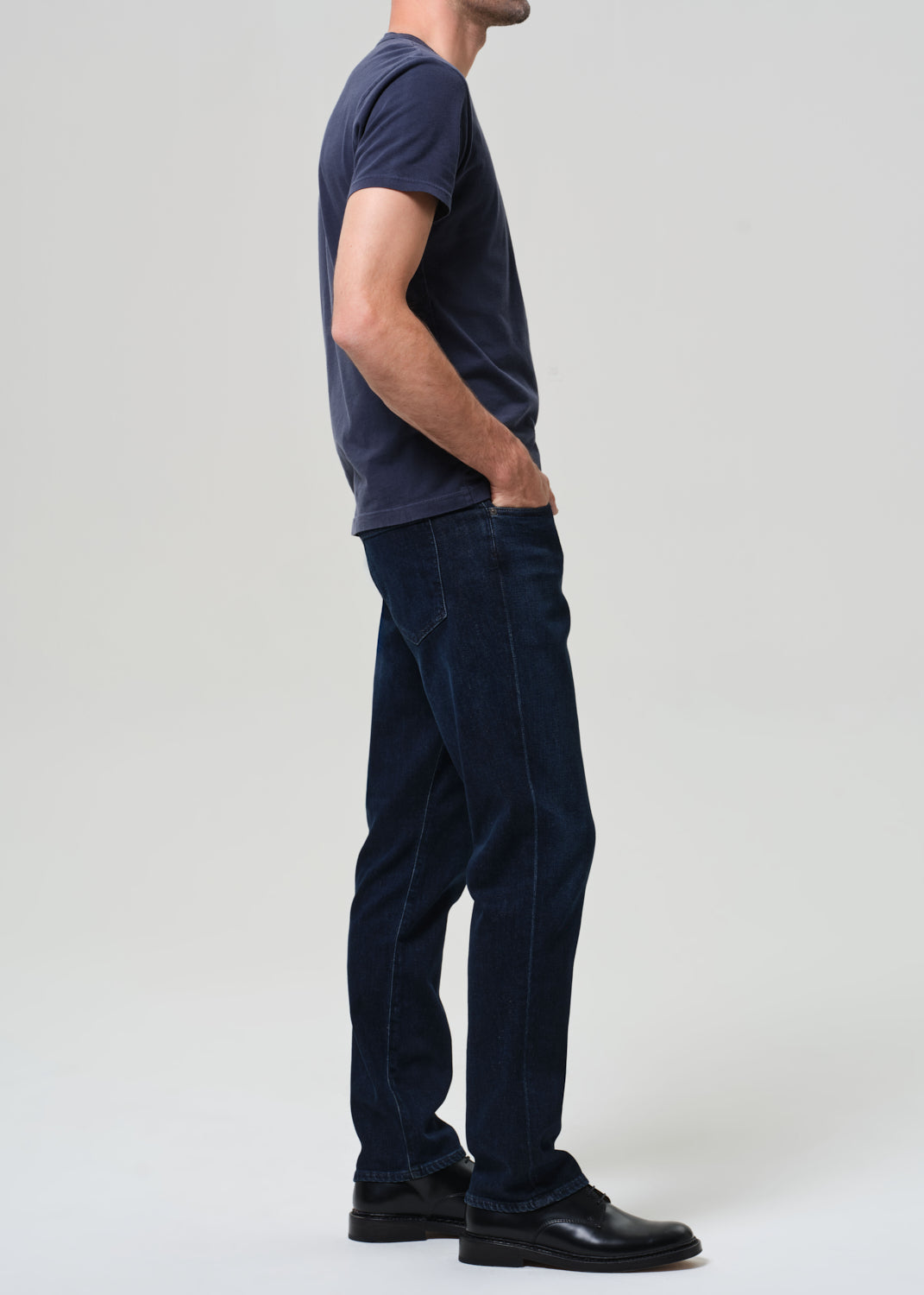 Person wearing a navy t-shirt and dark jeans 