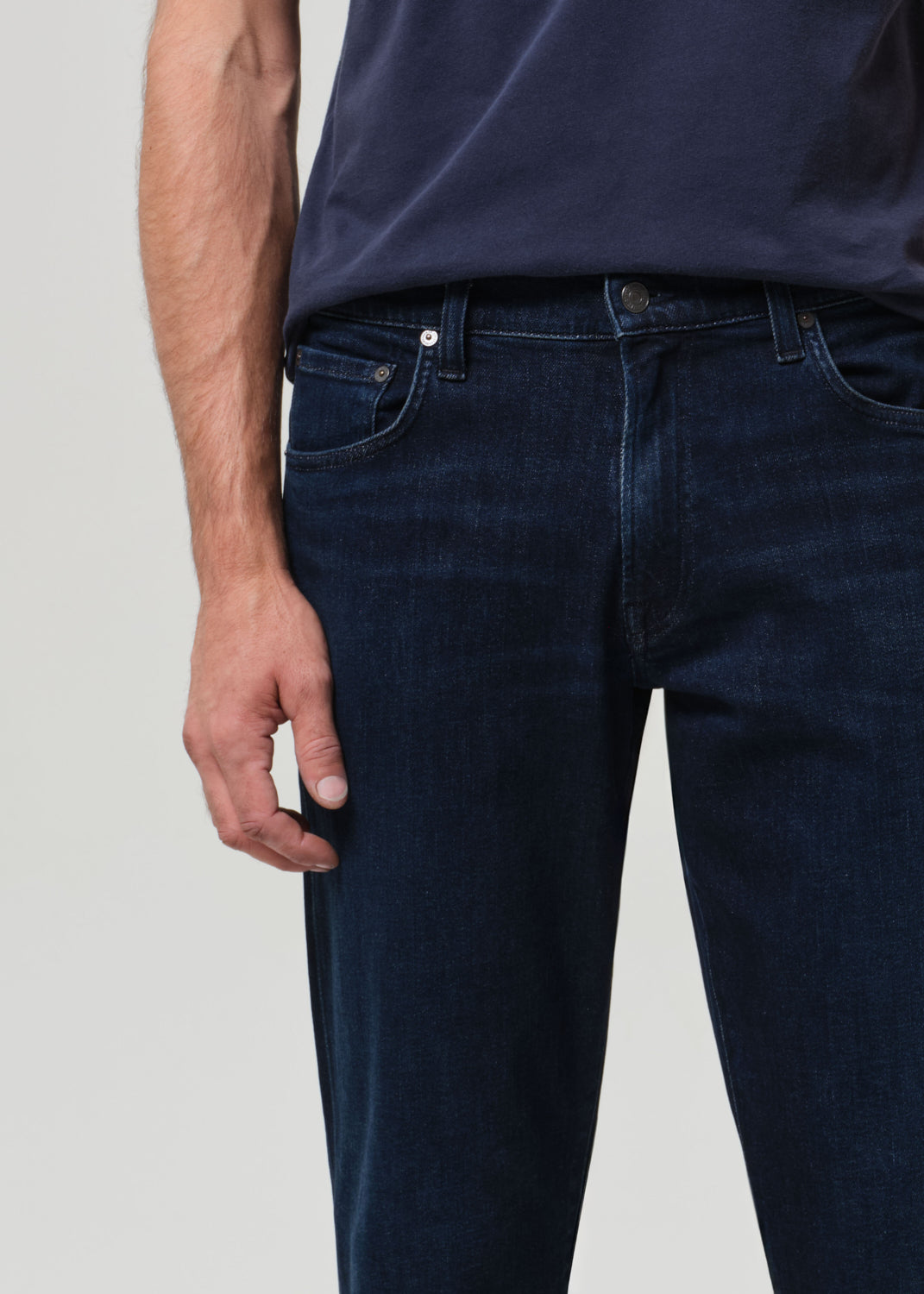 Person wearing a navy t-shirt and dark jeans 