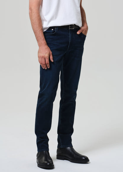 Person wearing a white t-shirt and dark jeans