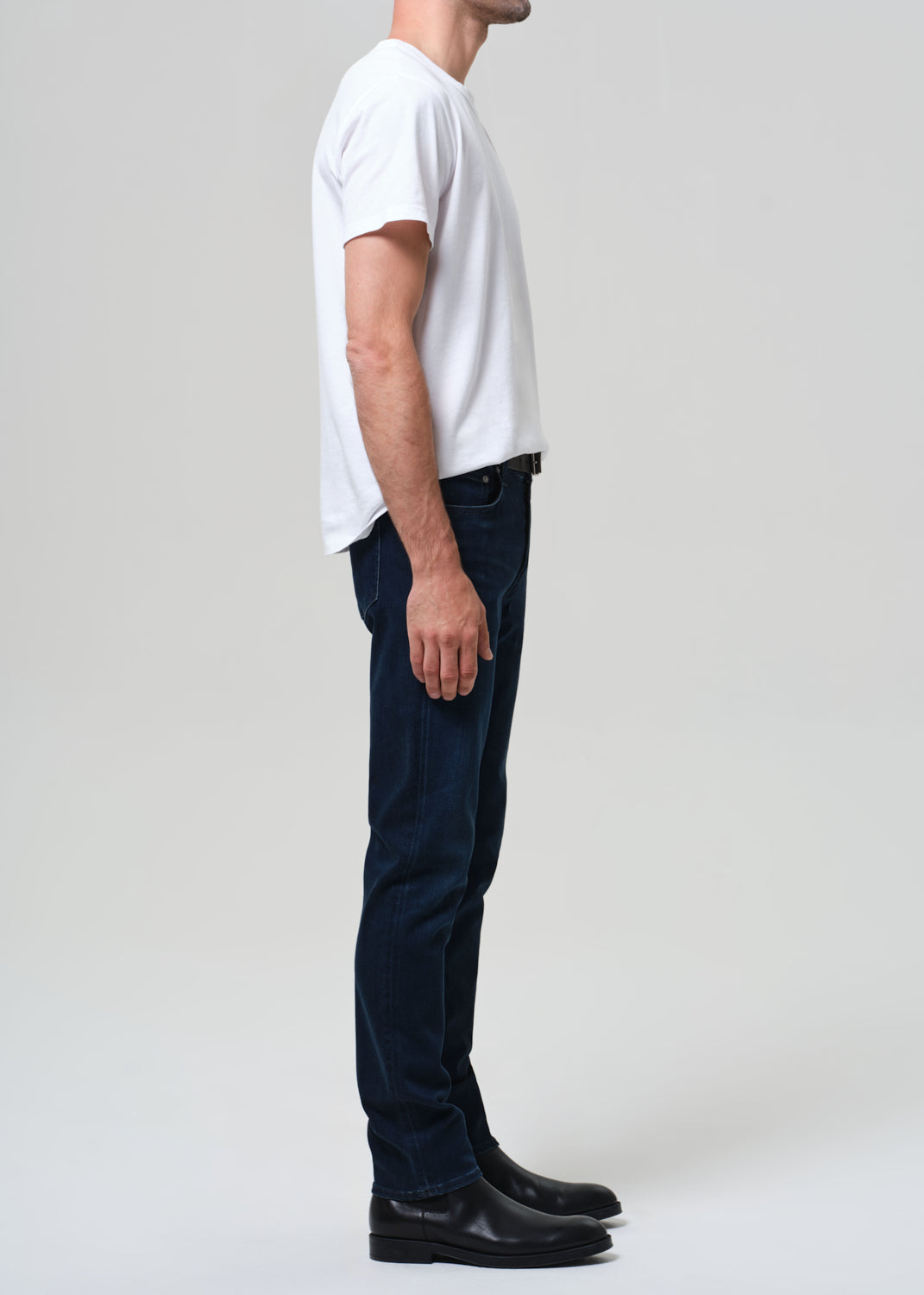 Person wearing a white t-shirt and dark jeans