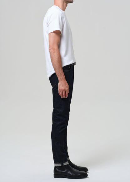 Person wearing a white t-shirt and black jeans on a plain background