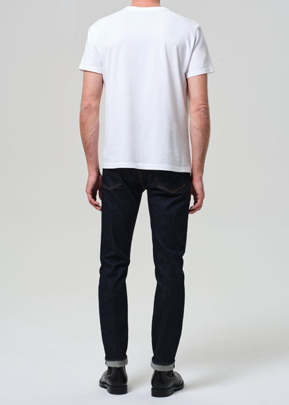 Person wearing a white t-shirt and black pants on a plain background