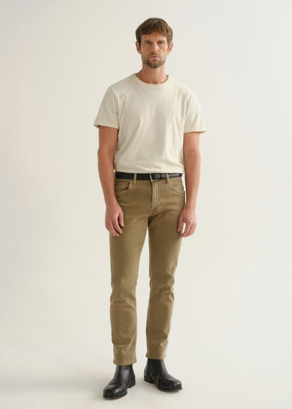 Person wearing khaki brown pants, a white short sleeve t-shirt, and black boots, front full body view on a light grey background.