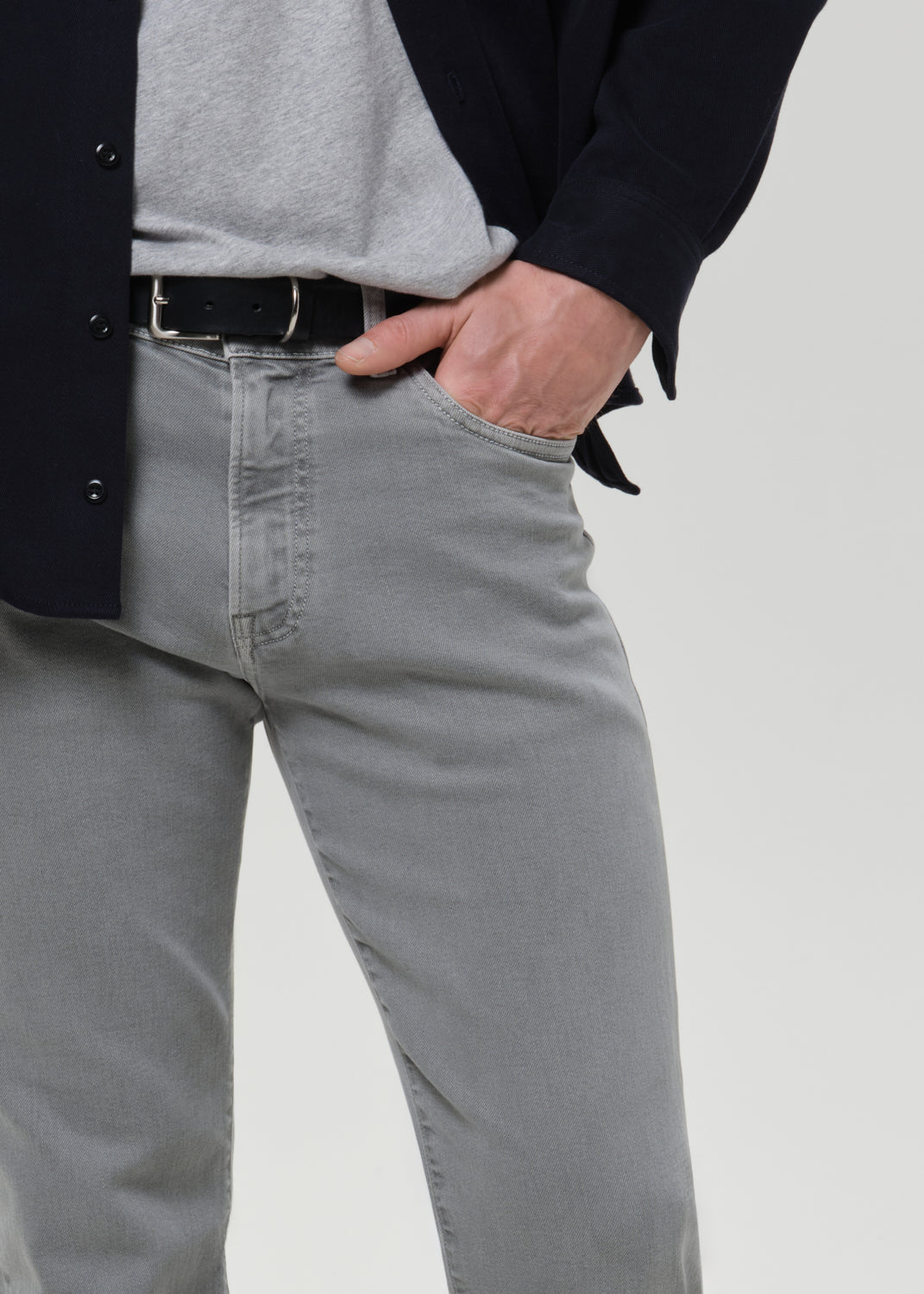 Person wearing grey  jeans with a grey background