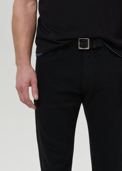 Person wearing black pants with a belt on a grey background