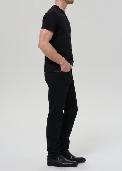 Person wearing a black t-shirt and black pants on a grey background