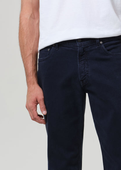 Navy blue jeans worn by a person on a light gray background