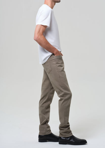 Person wearing a white t-shirt and olive pants on a plain background