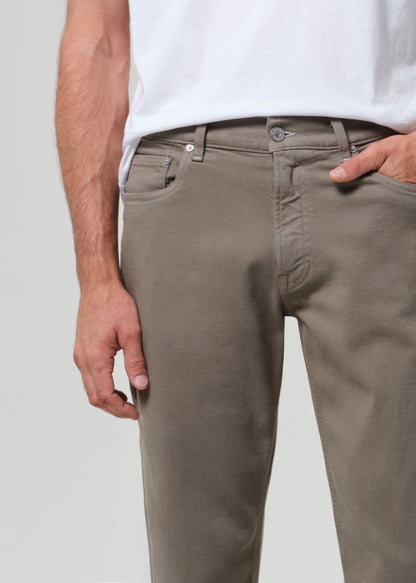 Person wearing a white t-shirt and olive pants on a plain background