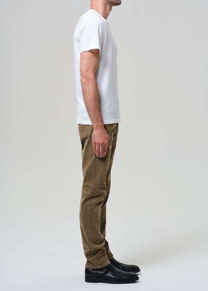 Person wearing a white t-shirt and brown pants on a plain background