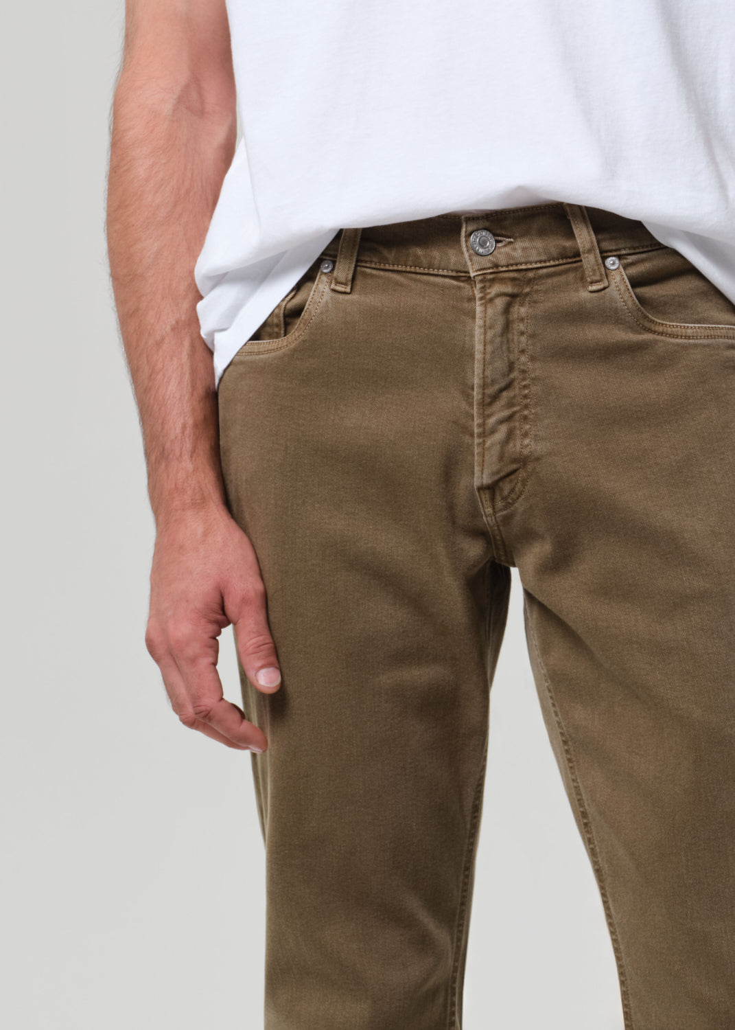 Person wearing brown pants on a grey background