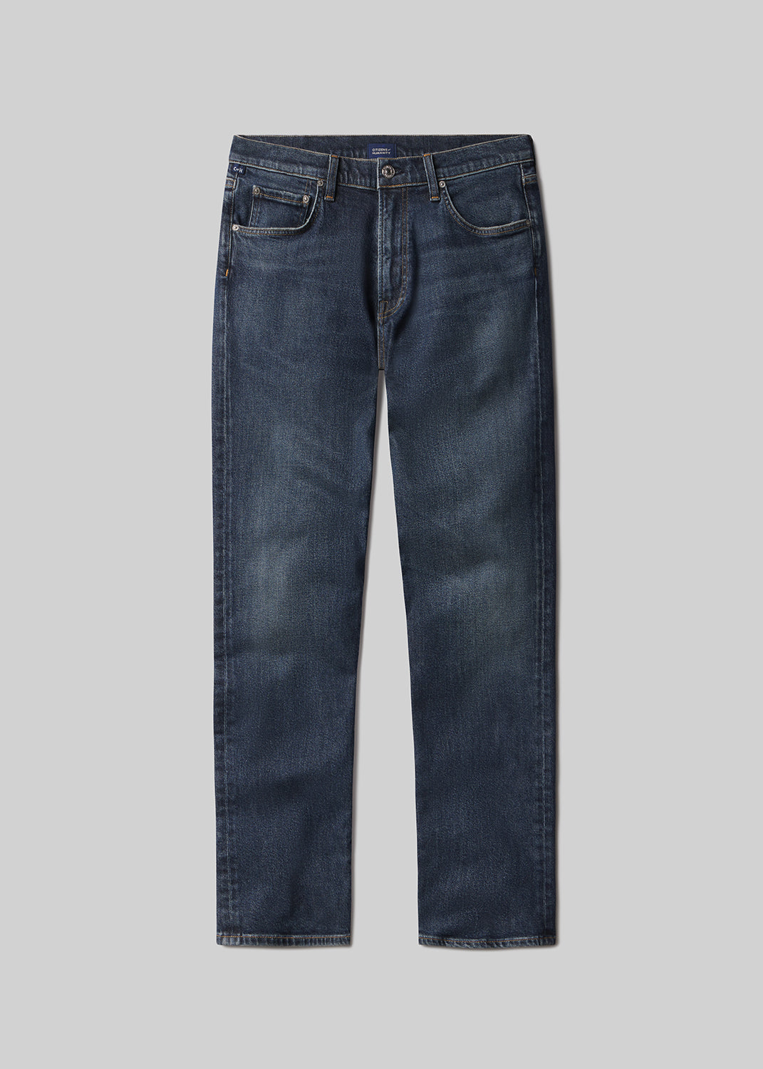 Flat lay shot of a pair of dark blue jeans on a grey background