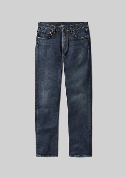 Flat lay shot of a pair of dark blue jeans on a grey background