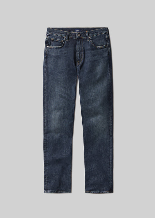 Flat lay shot of a pair of dark blue jeans on a grey background