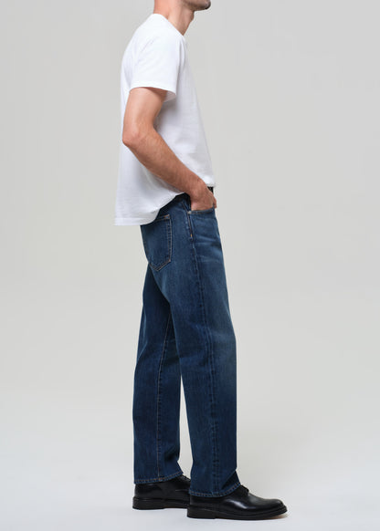 Person wearing a white t-shirt and blue jeans on a plain background