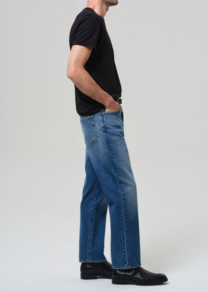 Person wearing blue jeans and a black shirt on a plain background
